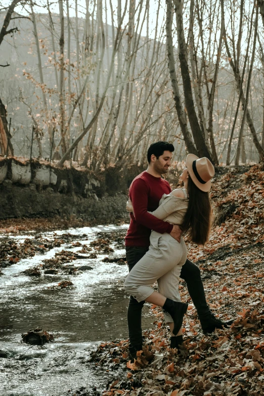 a couple playing on the river and kissing