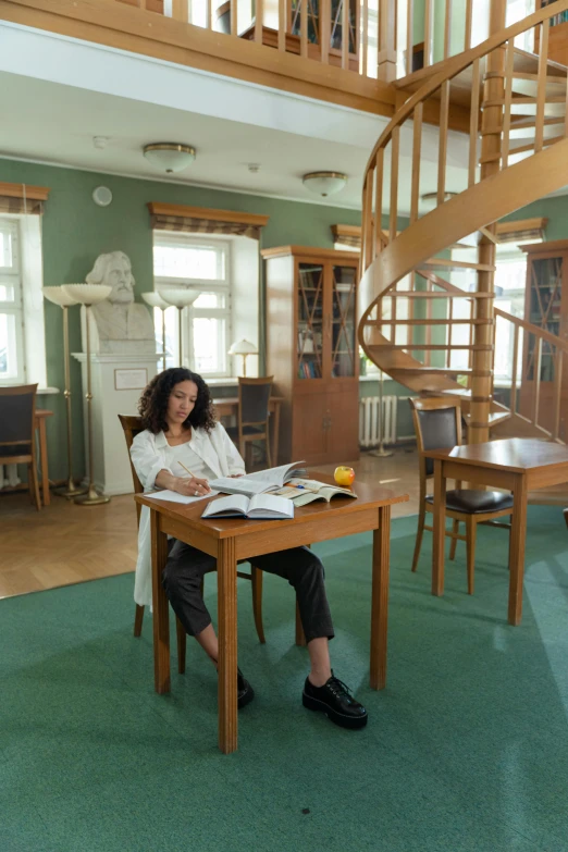 the woman is sitting at a table with papers