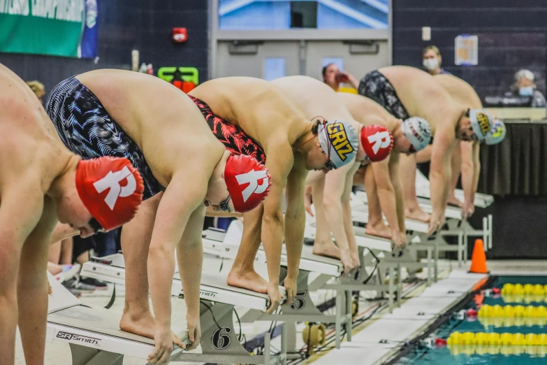 men in swimsuits preparing to enter the pool