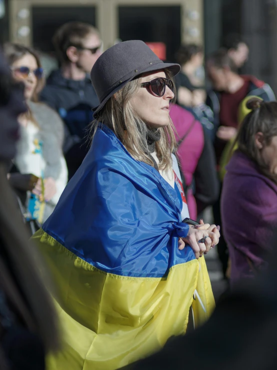 a lady in a blue and yellow cape in a crowd