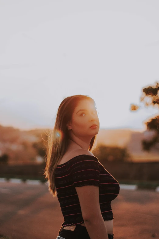 a woman with long hair standing in the field