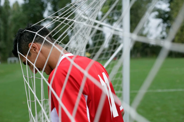 a closeup view of the back of a man's face behind a soccer goal