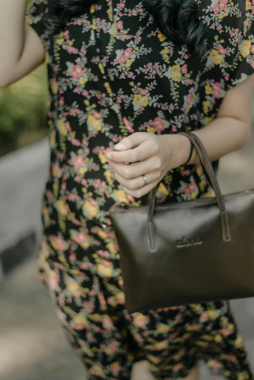 woman in floral print dress carrying brown bag