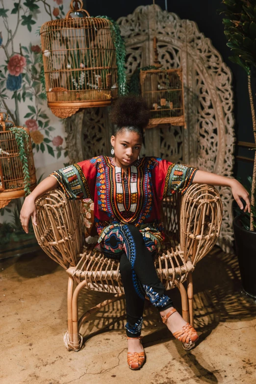 a  sitting in a rattan chair with birds on its back