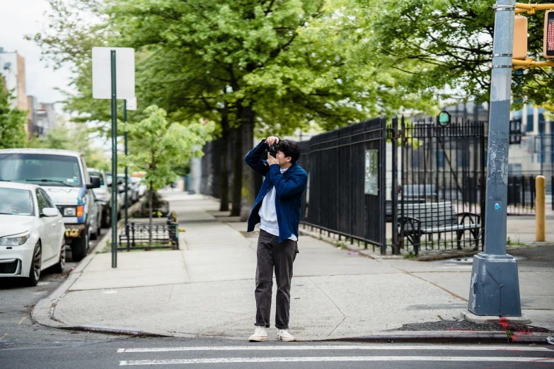 a man standing on a sidewalk talking on a cell phone