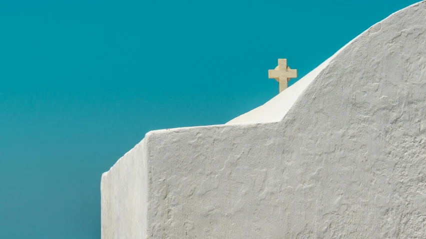 there is a white stone wall with a cross on it