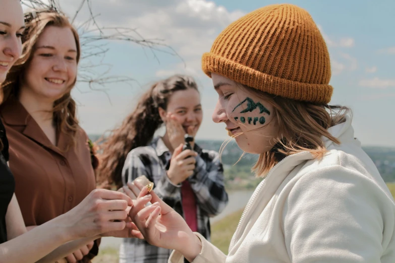 a girl with painted face paint standing near a group of girls