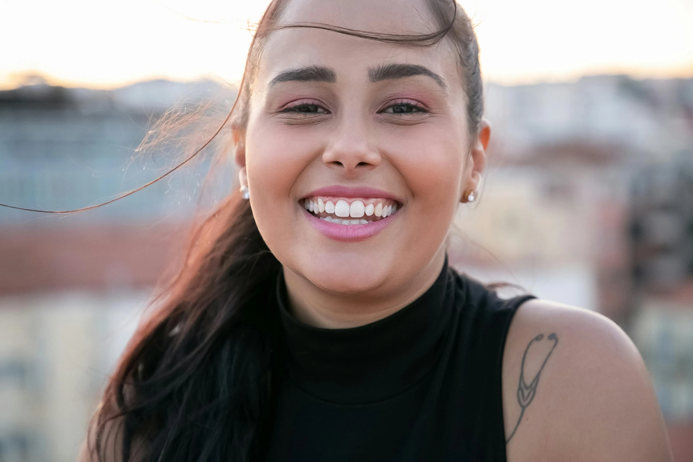 a woman with her hair blown back smiles