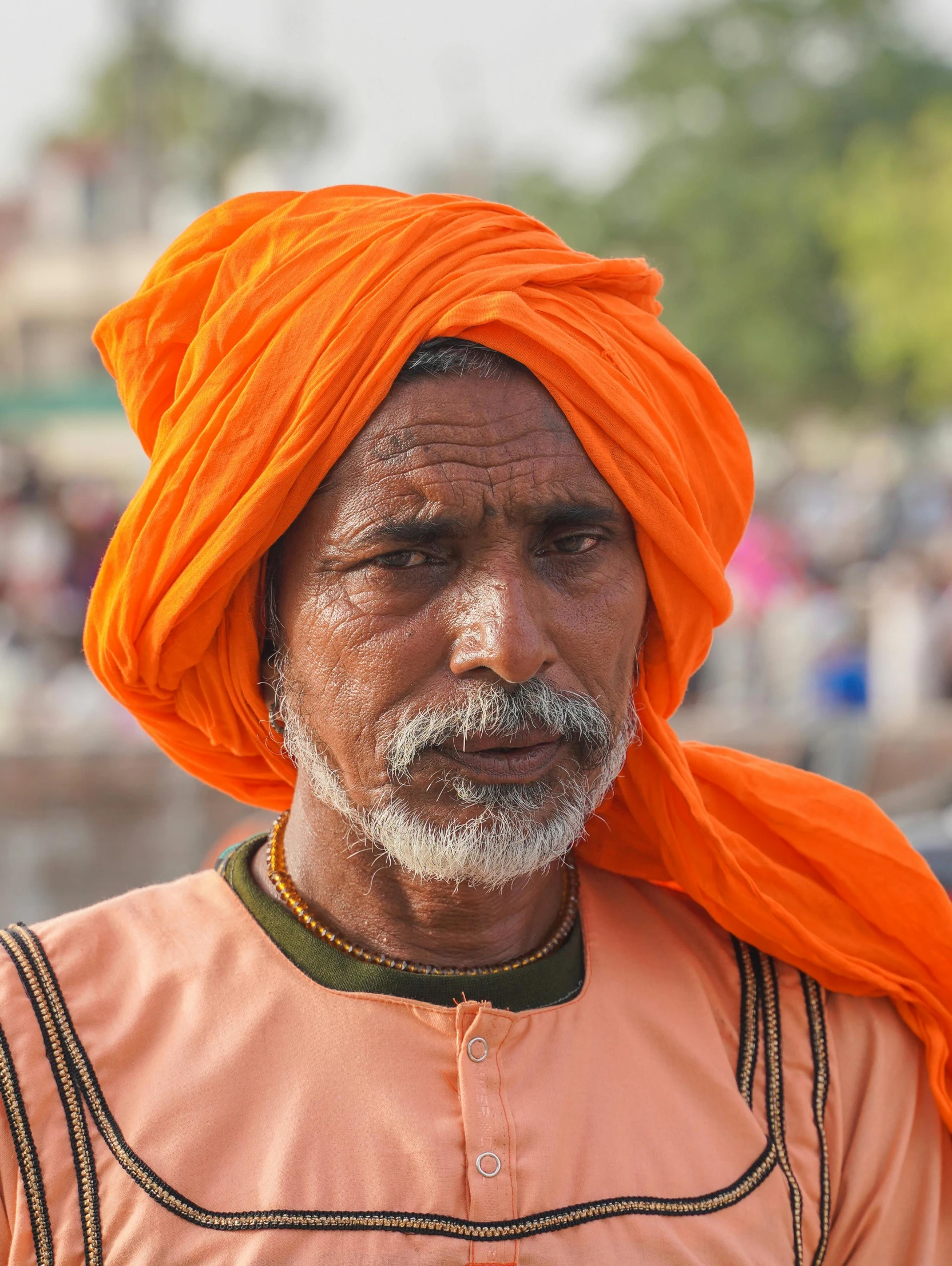 an indian man wearing a turban and orange scarf