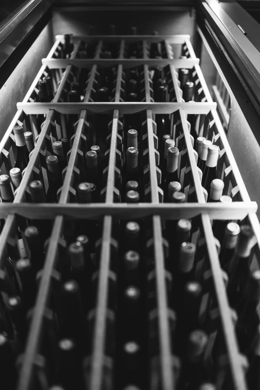 the bottom drawer of a wine refrigerator is full of bottles