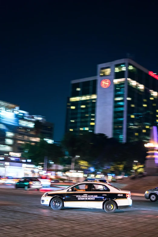 cars driving down a road in the city at night