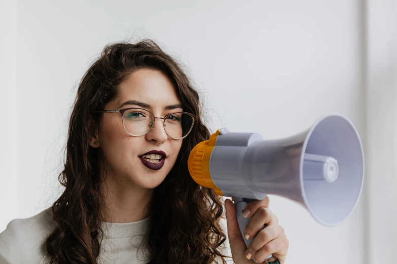 a woman wearing glasses and holding a microphone