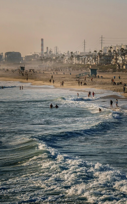 many people are swimming and relaxing on the beach