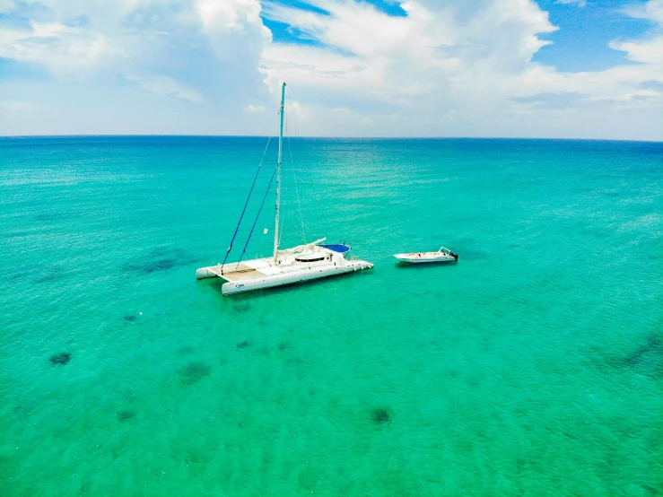 a boat with two sails sitting on the water