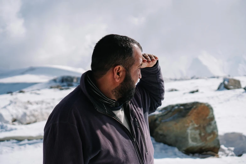 a man holding his hands up in the air and looking into the distance