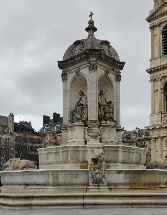 a white statue next to a large clock tower