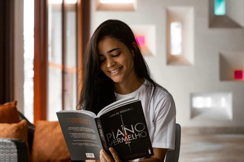 a smiling girl reads a novel in the liry