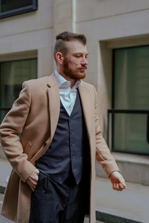 man walking down the street wearing a tan suit with brown jacket and white shirt