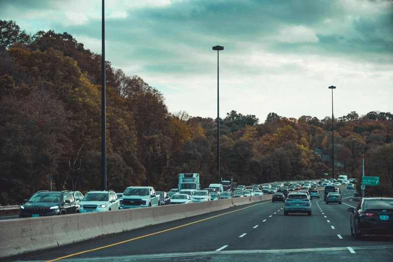 many cars driving on an interstate during the day