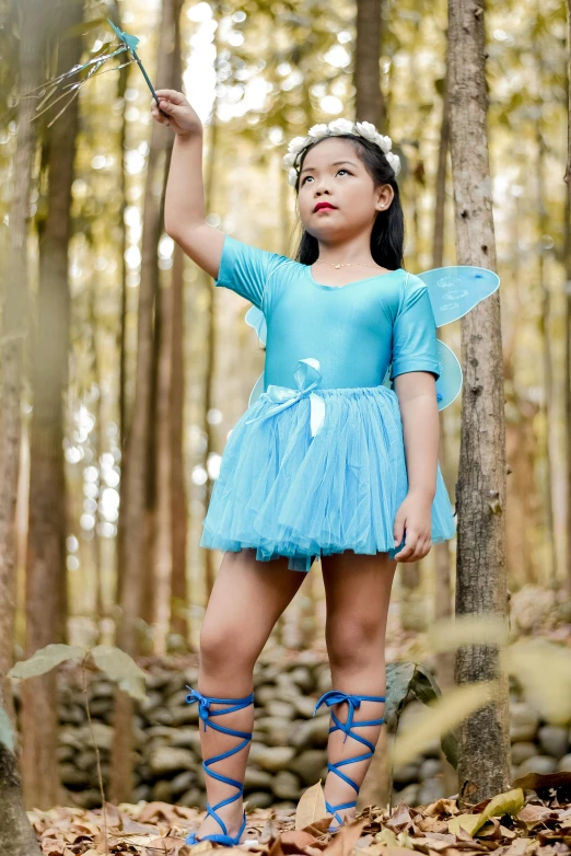 the child is dressed as an angel while posing for the camera