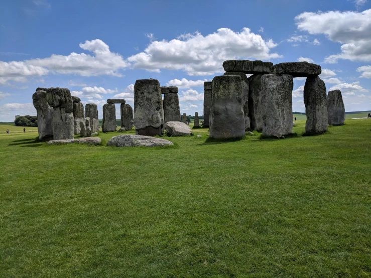 a large stonehenge sitting on top of a lush green field