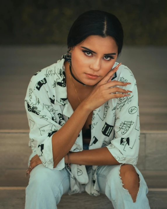 a young woman sitting down with her hands on the face