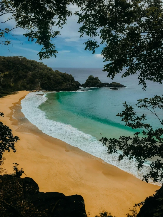 there is a beach with a few waves and blue water