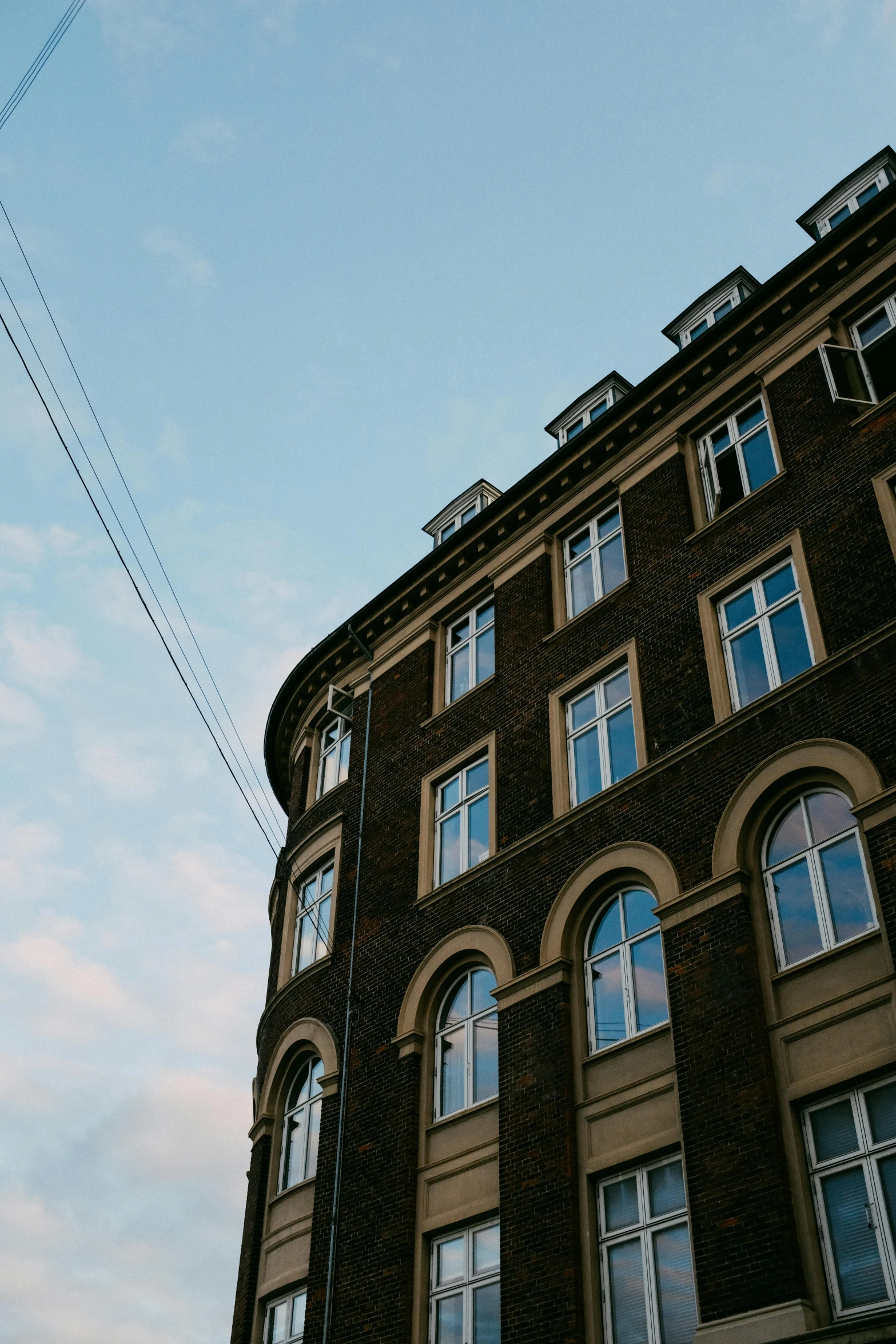 two electrical lines running past an old, brick building