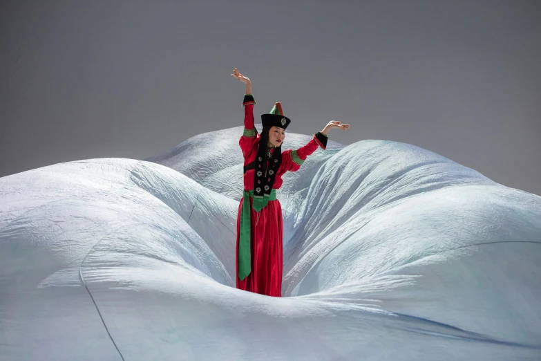 woman in red gown standing on white, snowy surface