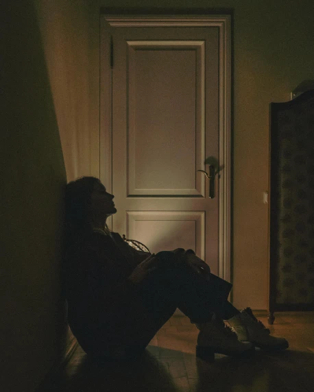 a silhouette of a person sitting in a dark room