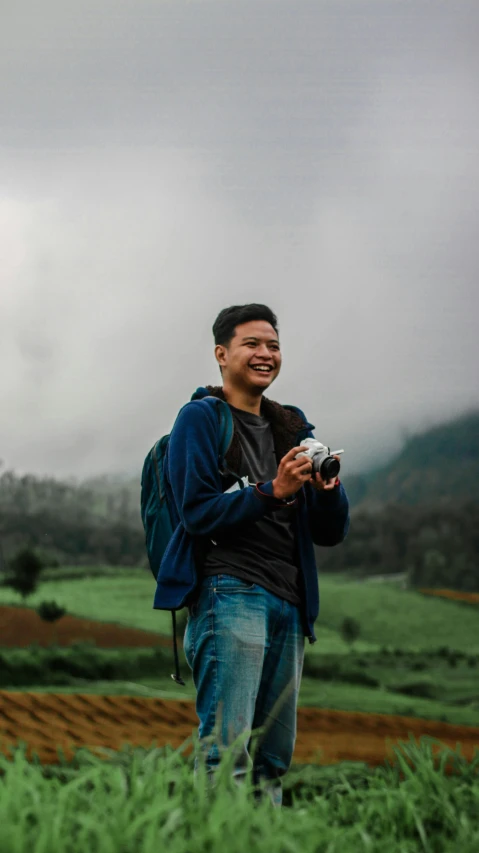 a man holding soing with a sky background