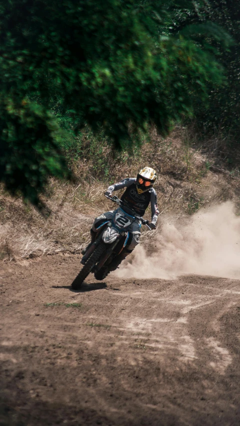 dirt bike racer sliding down hill on a dirt track