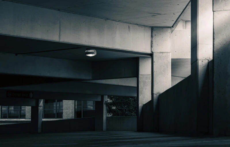 an empty parking garage with dark colors and concrete walls
