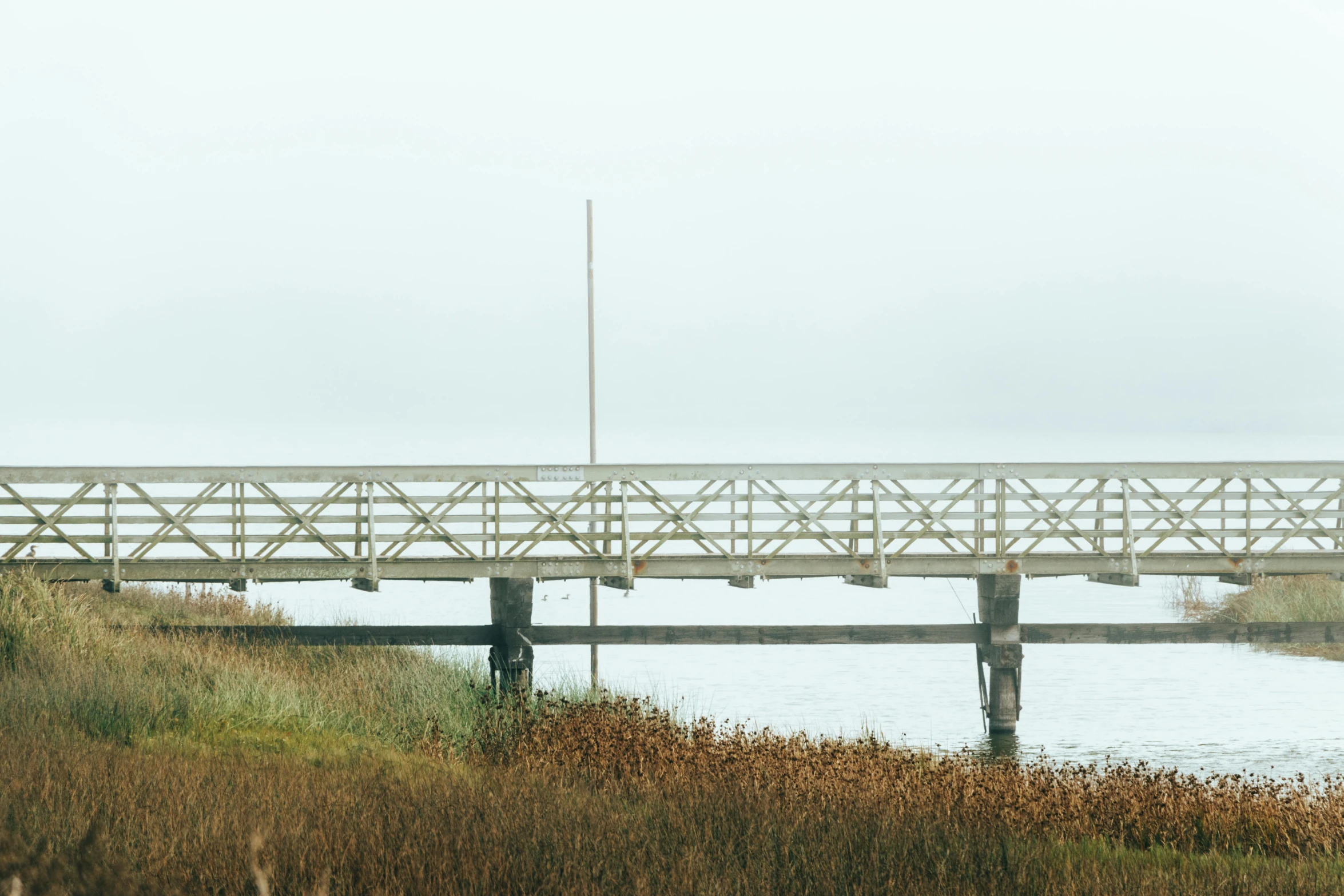 a white wooden bridge spanning across a river