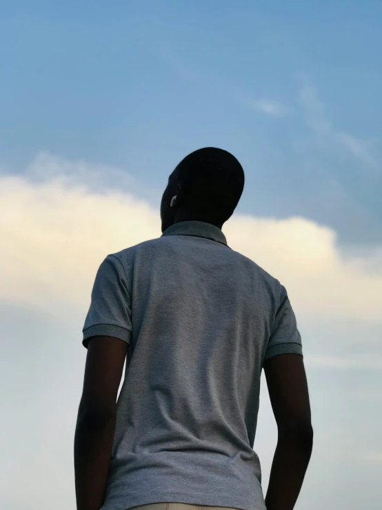 the silhouette of a man wearing a gray polo - neck shirt