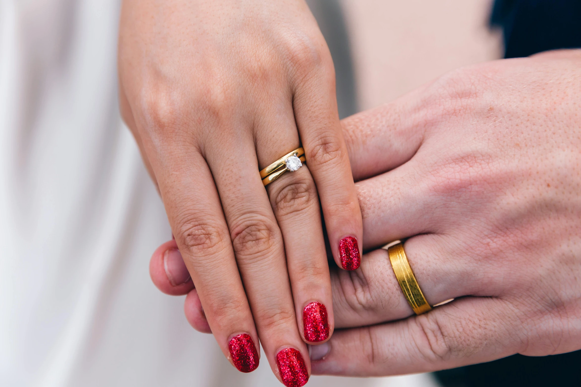 an image of two people holding hands with rings