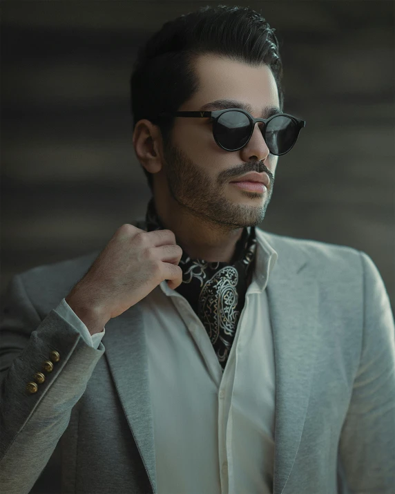 a man wearing a tie and sunglasses putting on a jacket