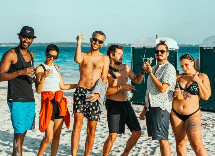 six people posing for a picture on a beach