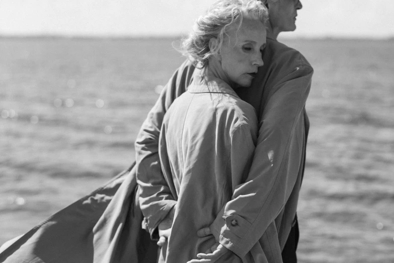 a man and woman standing on the beach