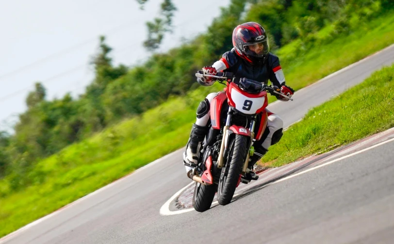 a man riding on the back of a red motorcycle