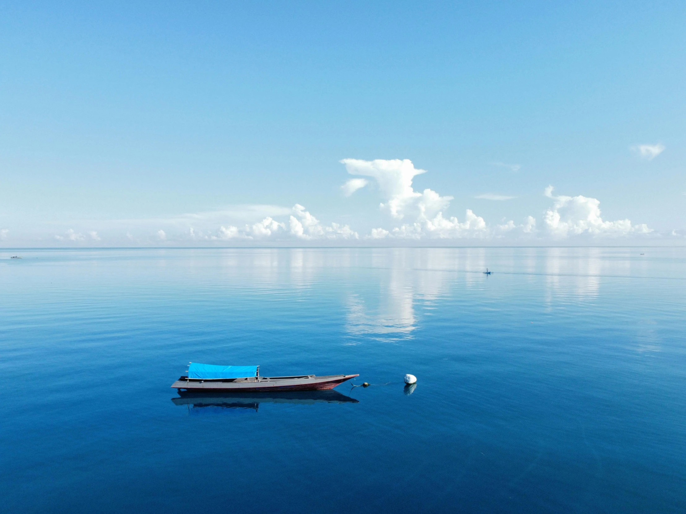 a small boat floating on top of a large body of water