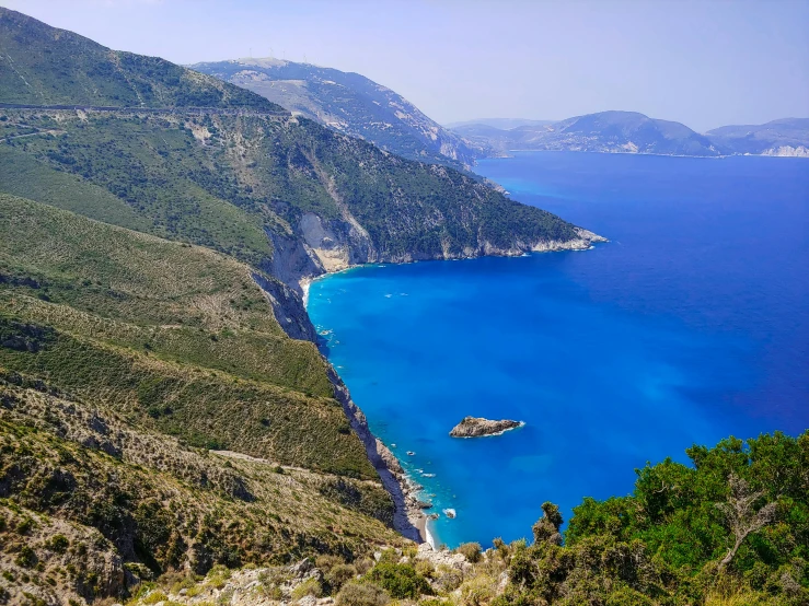 a view over the ocean and coast with rocky mountains in the background