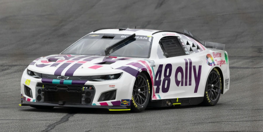 a white car with stripes and logo drives along the track