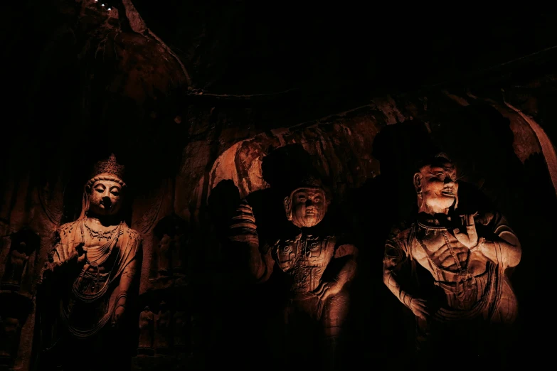 statues sitting in a black room next to each other