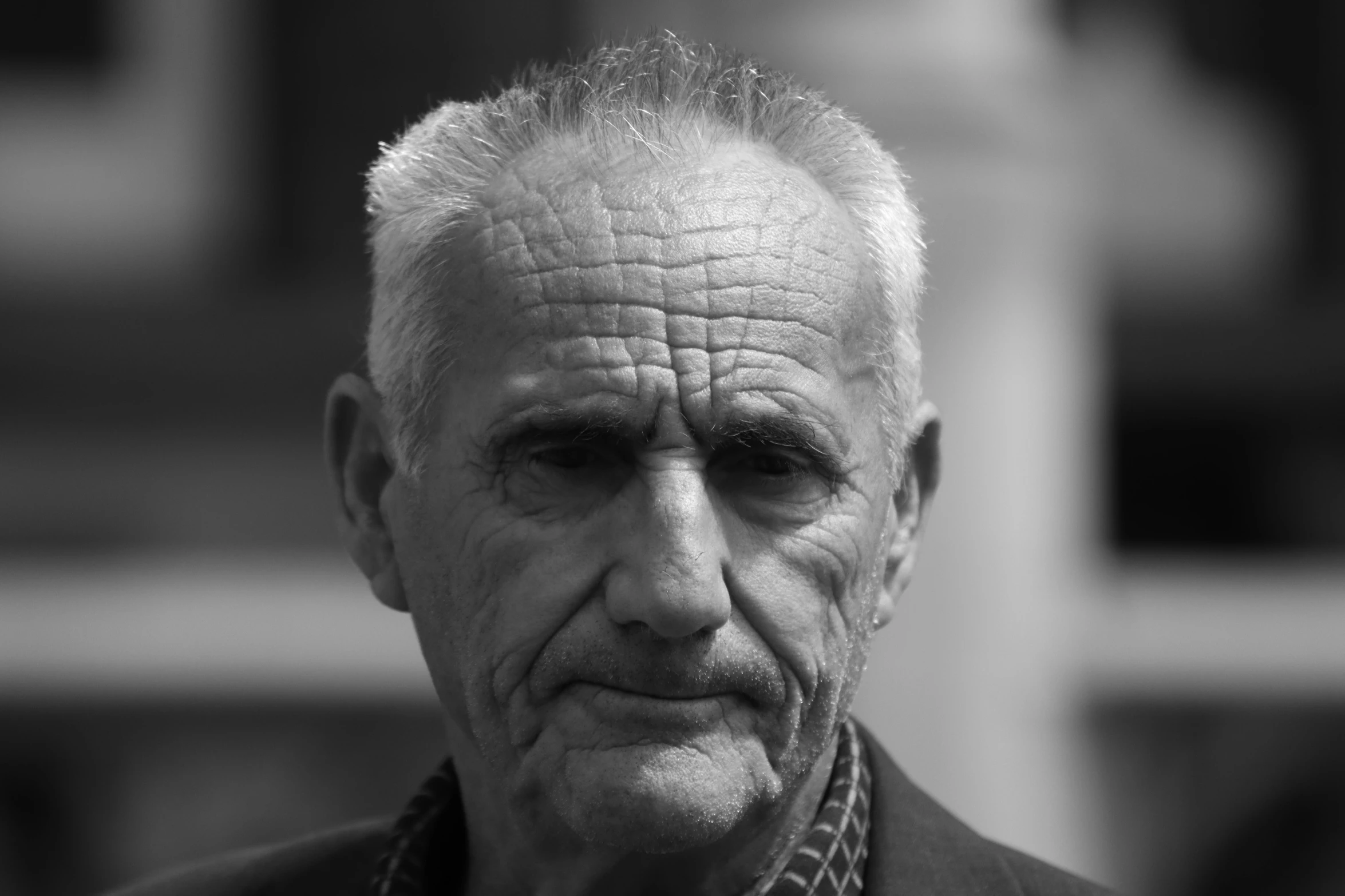 an old man looking pensive while standing outside