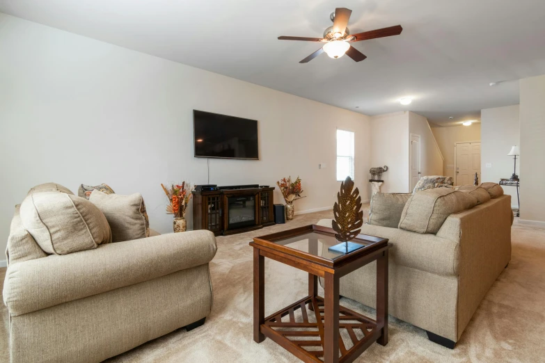 a living room with several furniture and a ceiling fan