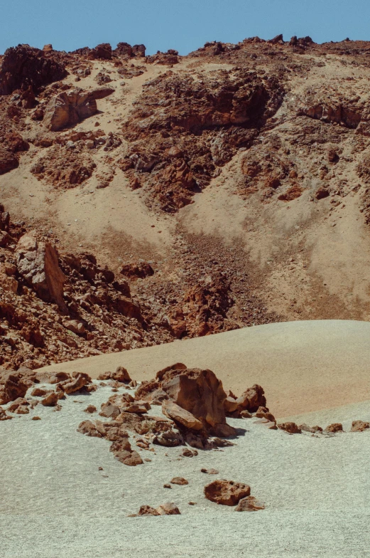 a rock formation sits in the desert with sp grass and rocks