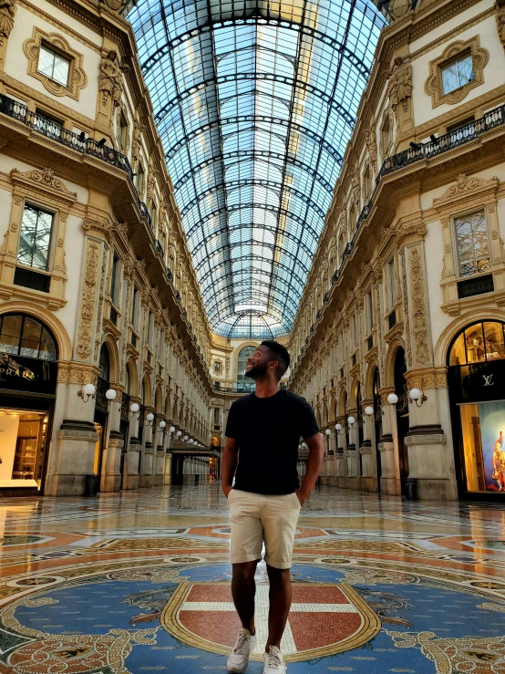a man stands in the center of an empty shopping mall