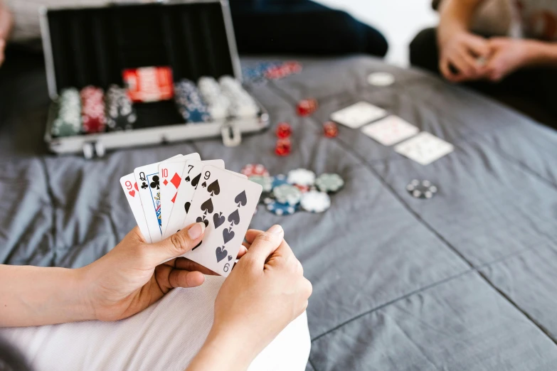 a person playing cards with a laptop on the side