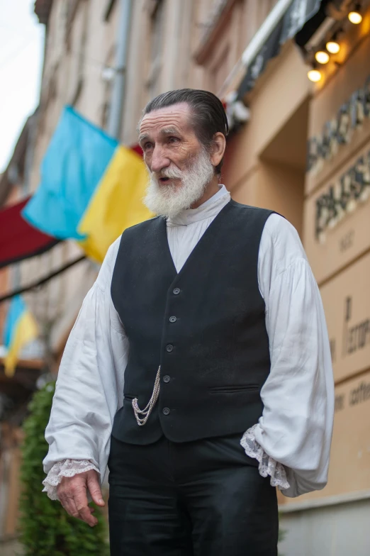 an old man in traditional hungarian clothing stands outside